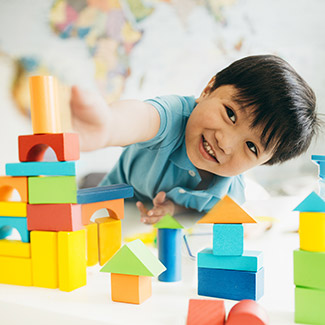 Un garçon construit une tour de blocs